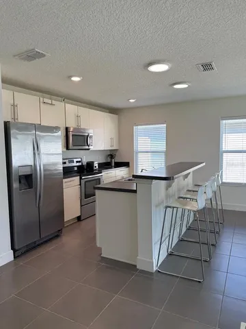 a kitchen with stainless steel appliances granite countertop a refrigerator sink and stove
