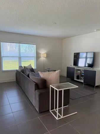 a living room with furniture a large window and a counter top space