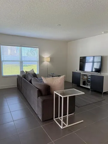 a living room with furniture a large window and a counter top space
