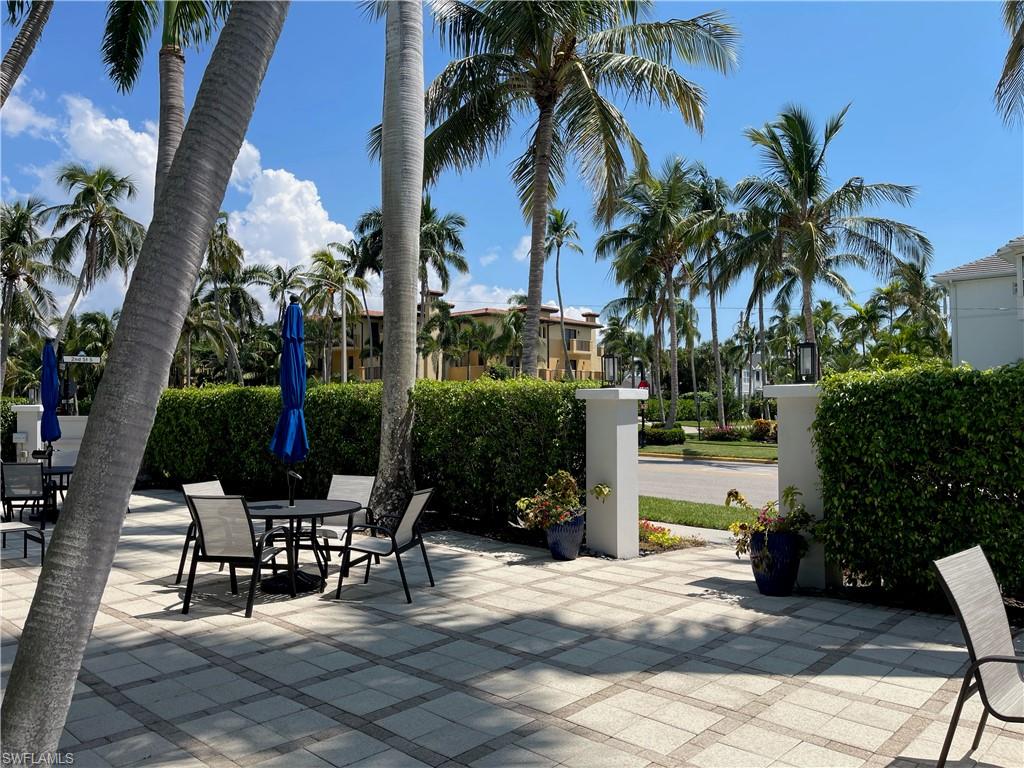 175 5th Avenue South, Unit 9 Naples, FL 34102 - Photo 11 of 19 a view of a patio with a table and chairs and potted plants