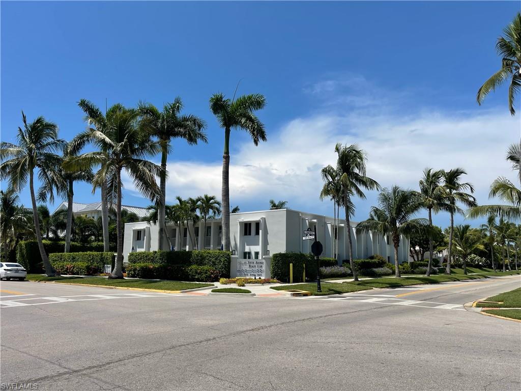 175 5th Avenue South, Unit 9 Naples, FL 34102 - Photo 14 of 19 front view of a house with a yard and palm trees