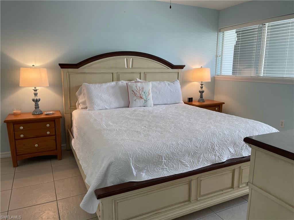 175 5th Avenue South, Unit 9 Naples, FL 34102 - Photo 4 of 19 a bedroom with a bed and a night stand