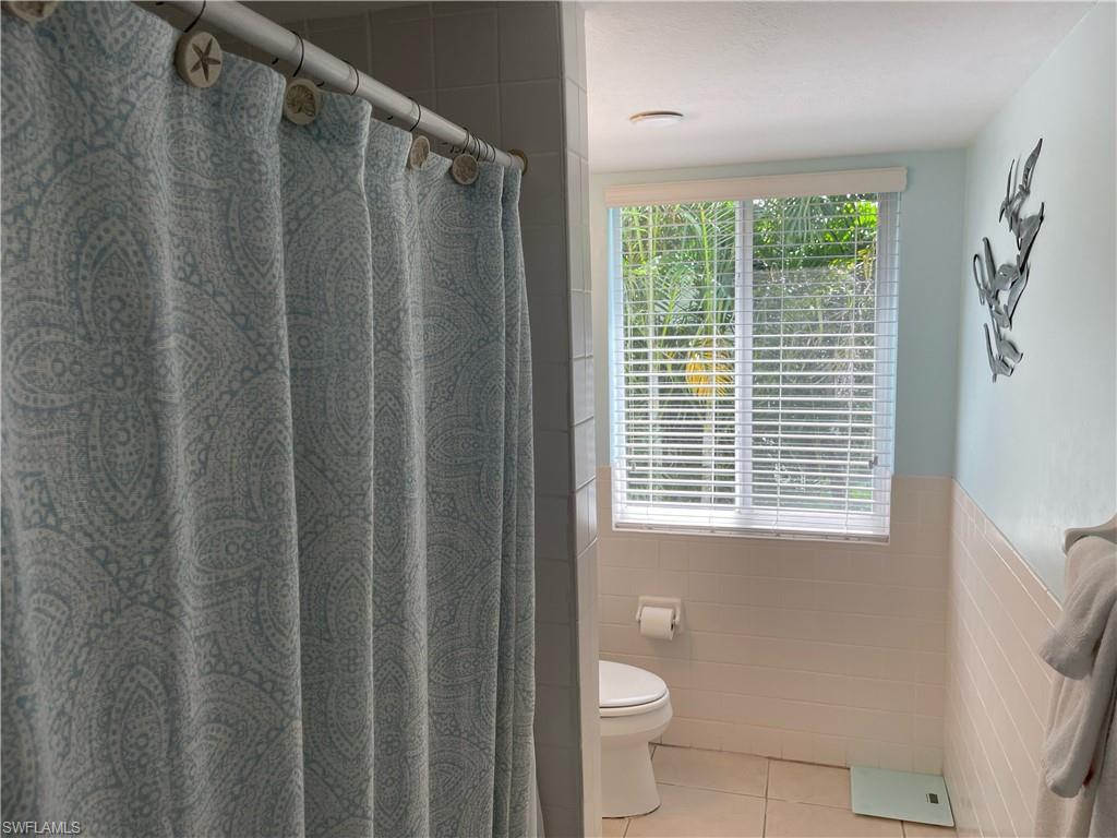 175 5th Avenue South, Unit 9 Naples, FL 34102 - Photo 5 of 19 a bathroom with a granite countertop sink toilet and a shower