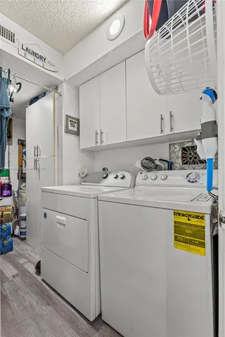 a utility room with cabinets washer and dryer