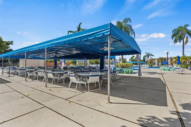 a view of a patio with a table and chairs under an umbrella