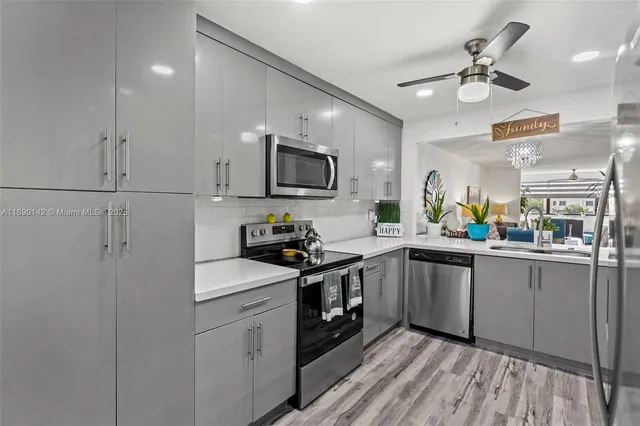 a kitchen with a sink stainless steel appliances and white cabinets