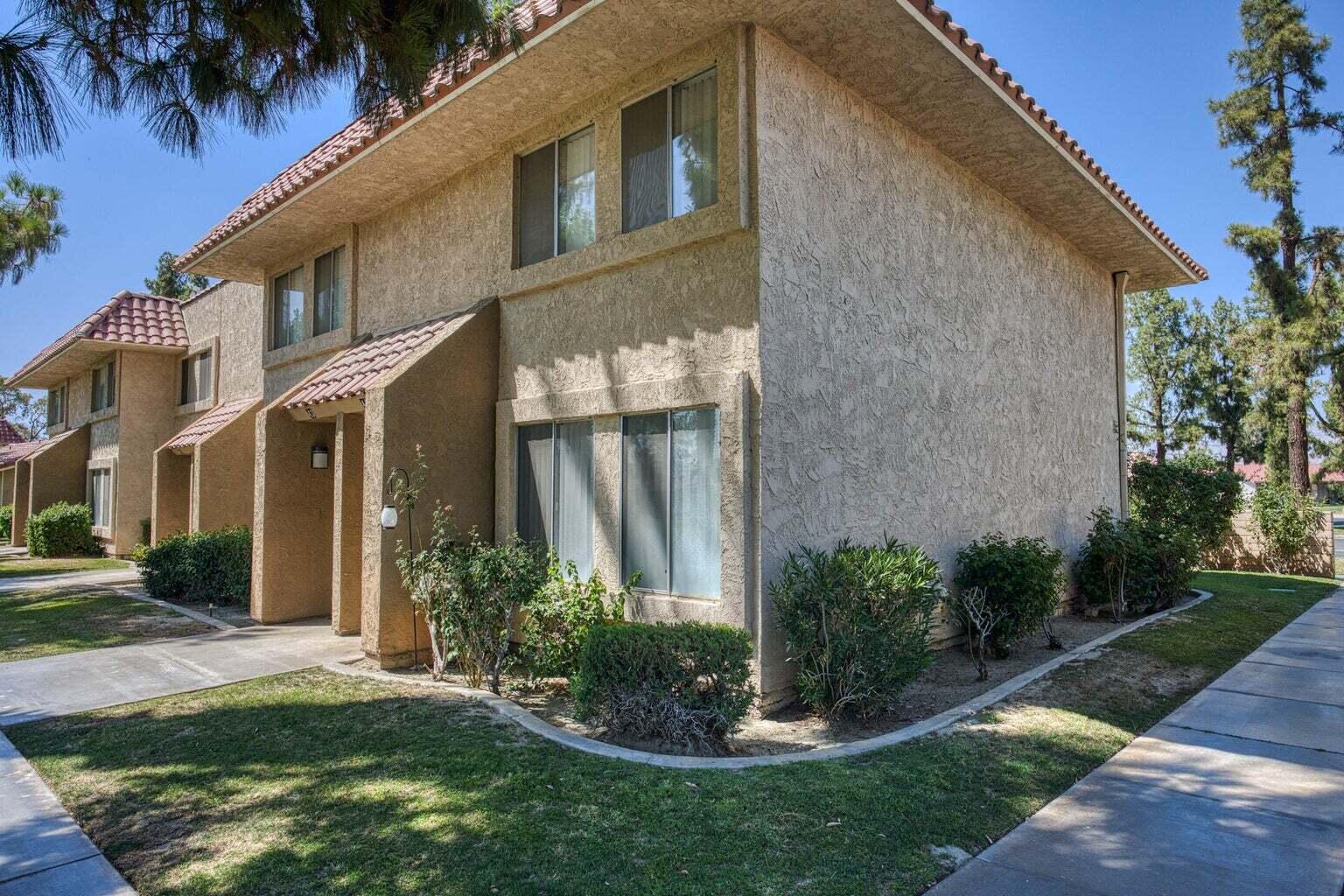82567 Ave 48, Unit 44 Indio, CA 92201 - Photo 11 of 19 a view of a house with brick walls and a yard with plants