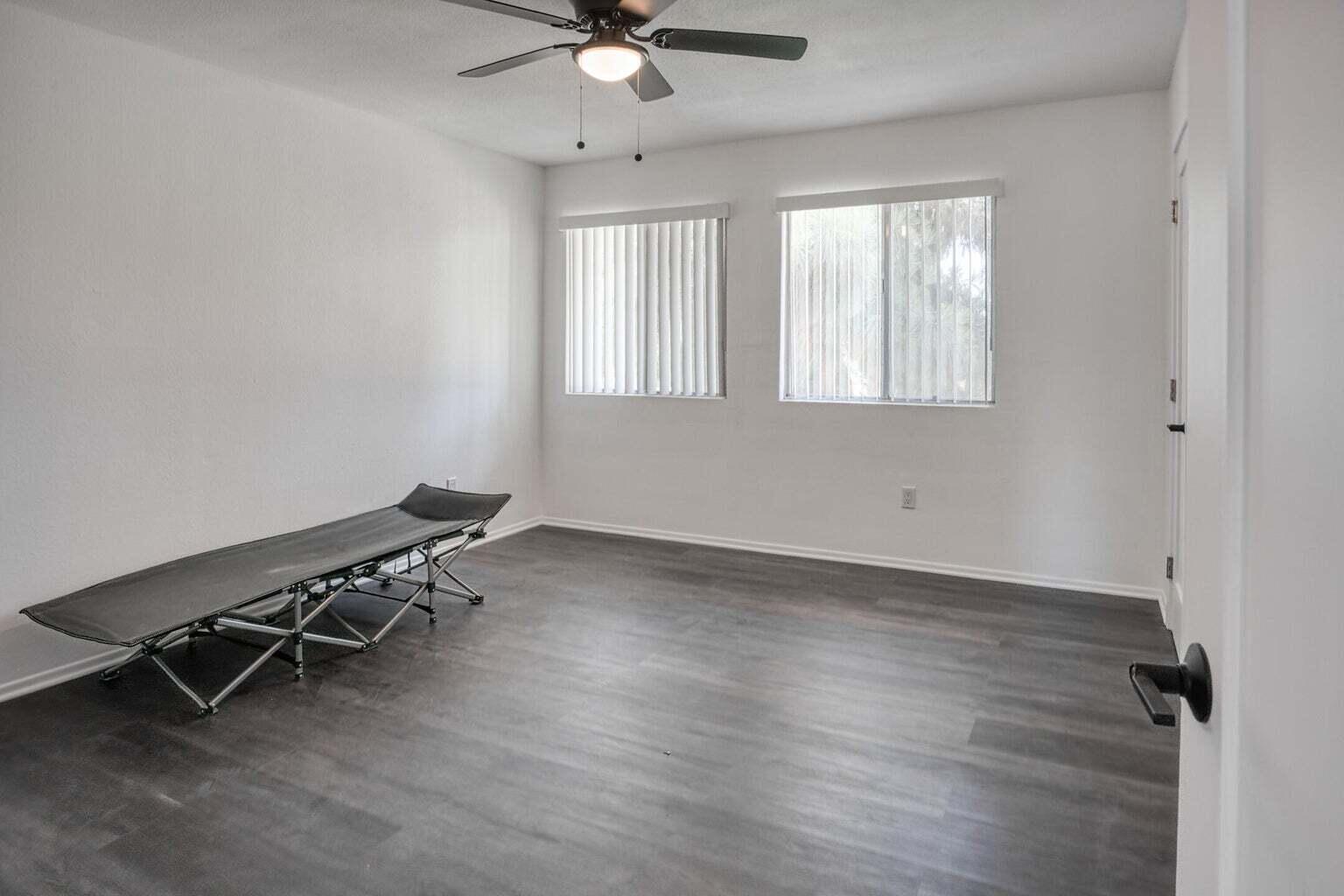 82567 Ave 48, Unit 44 Indio, CA 92201 - Photo 8 of 19 an empty room with wooden floor fan and windows