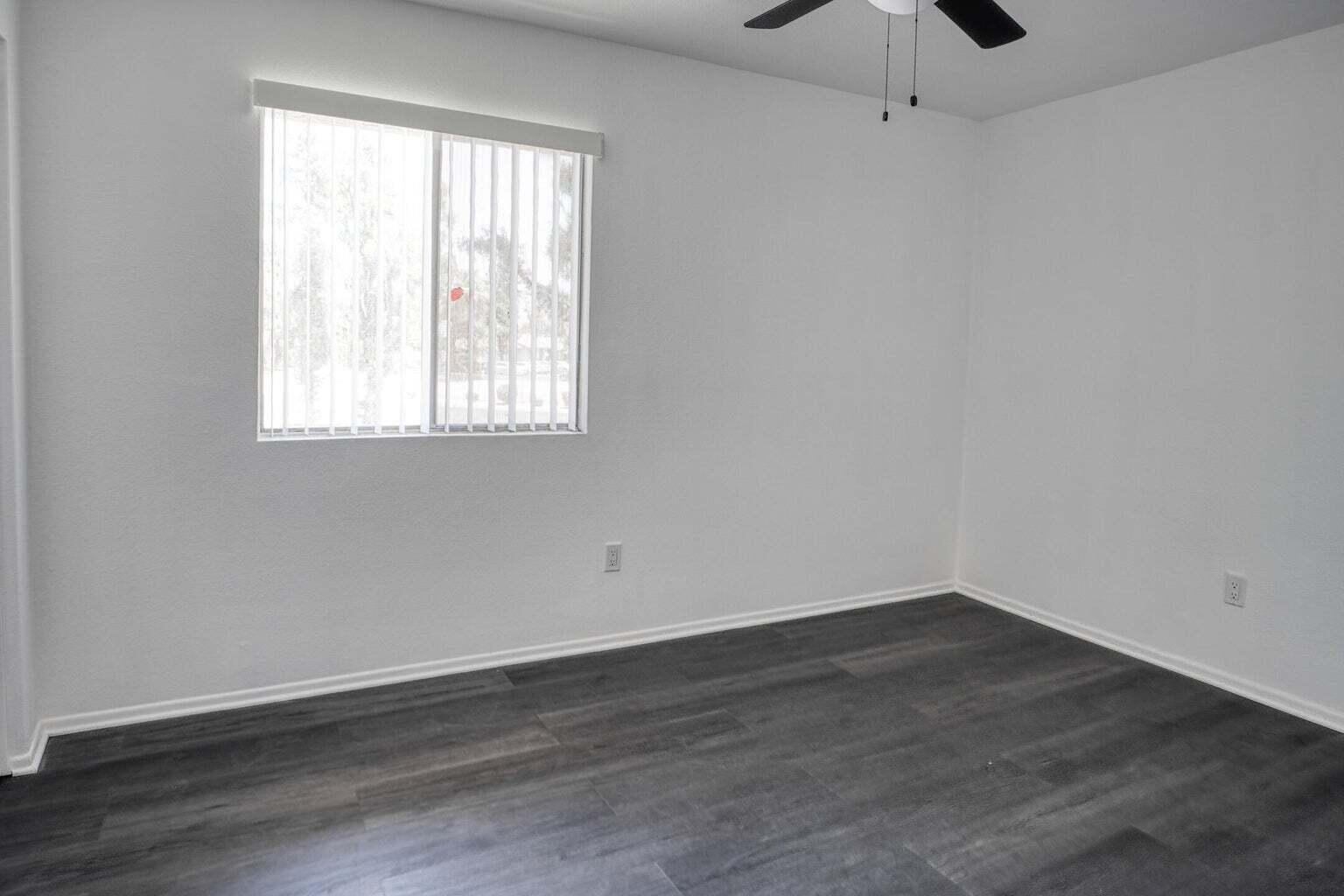 82567 Ave 48, Unit 44 Indio, CA 92201 - Photo 9 of 19 an empty room with wooden floor and windows