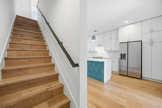a view of a kitchen with wooden floor and electronic appliances