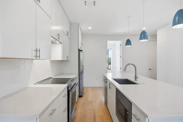 a kitchen with a sink a stove and cabinets