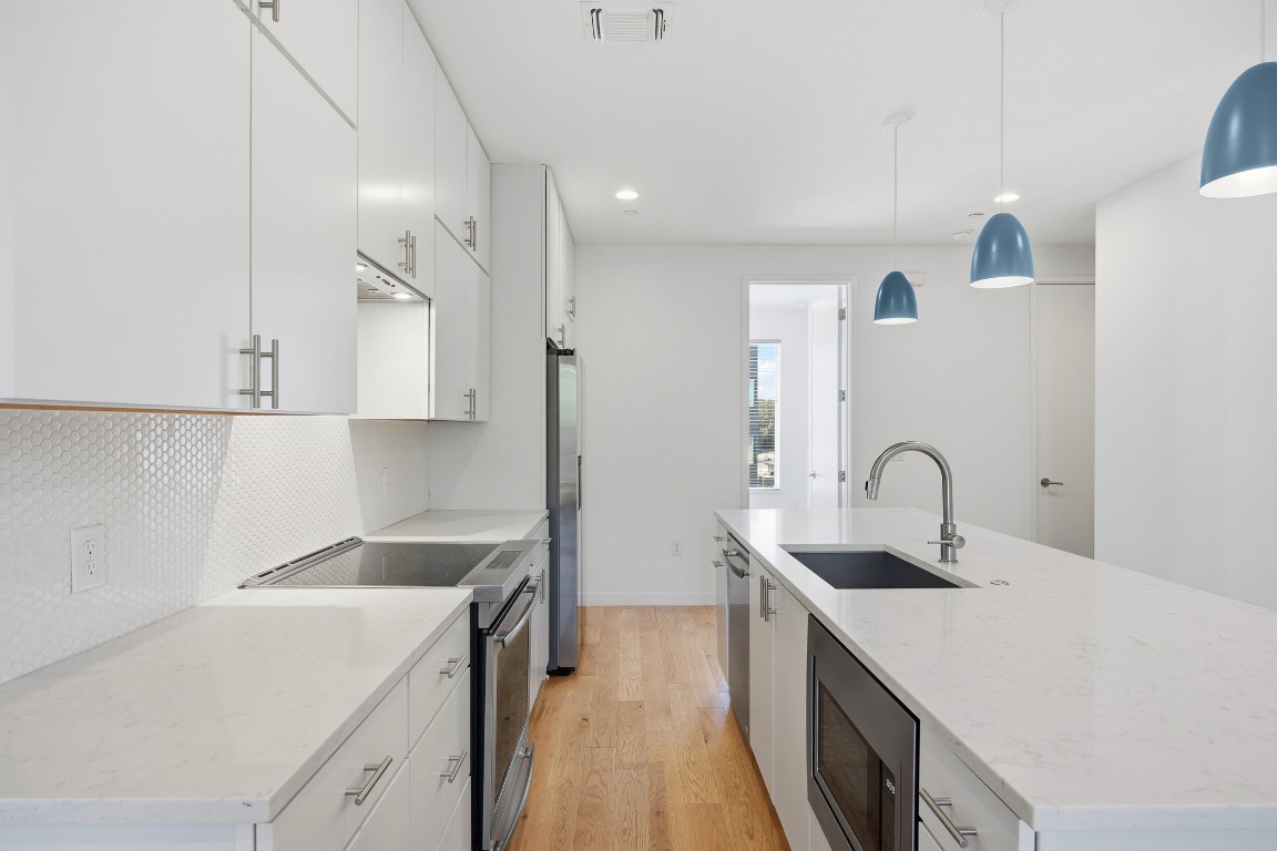 6020 Springdale Road, Unit 12 Austin, TX 78723 - Photo 3 of 28 a kitchen with a sink a stove and cabinets