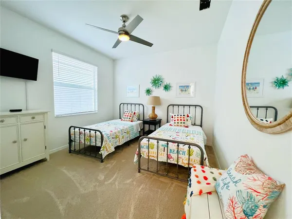 a bedroom with two beds and a chandelier