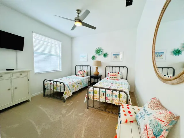 a bedroom with two beds and a chandelier