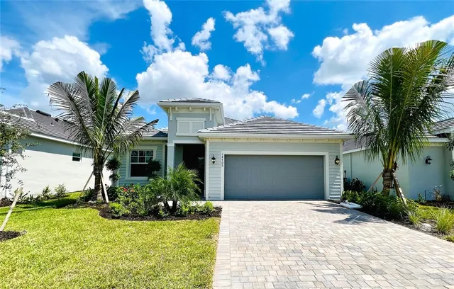 a view of a house with a yard and potted plants