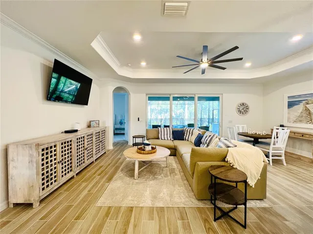 a living room with furniture tv and wooden floor