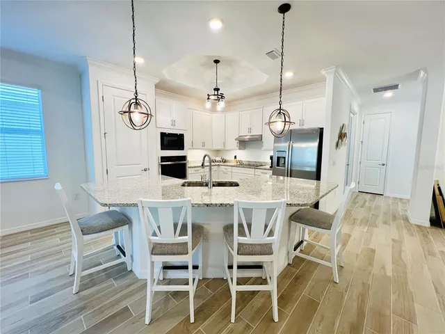 a dining room with furniture a chandelier and wooden floor