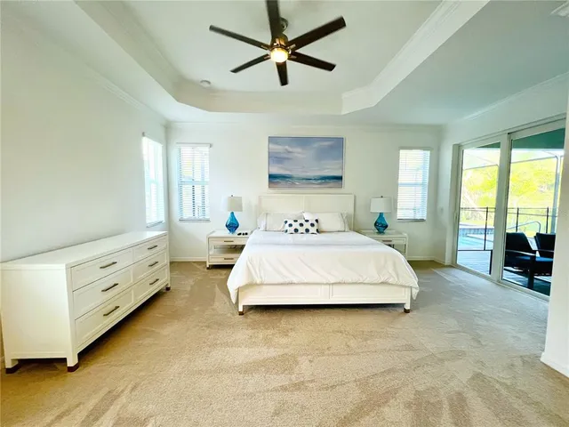 a spacious bedroom with a bed a chandelier and a couch