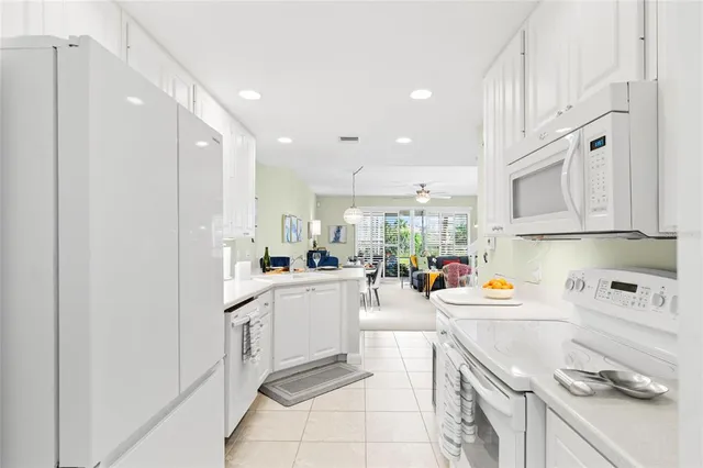 a kitchen with white cabinets and white appliances