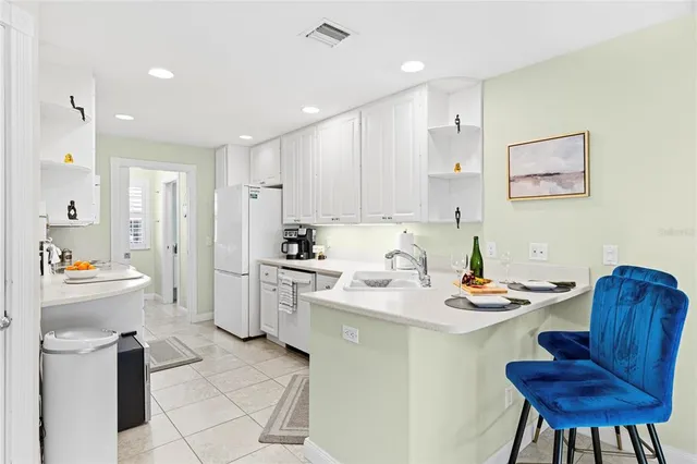 a kitchen with a sink dining table and chairs
