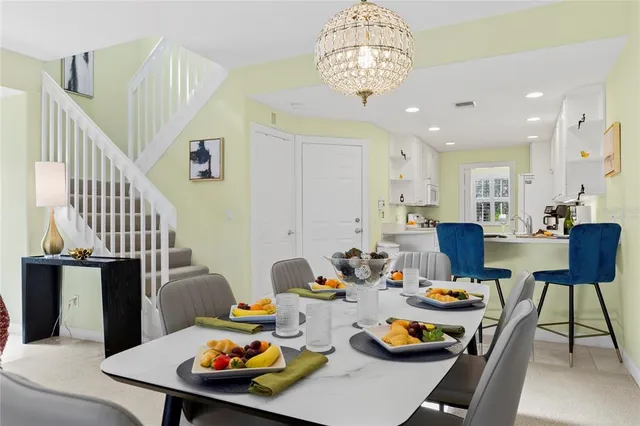 a outdoor dining room with furniture a chandelier and wooden floor