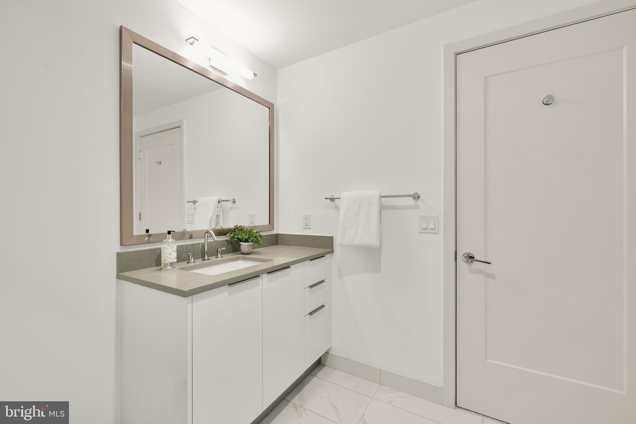 45 Sutton Square Southwest, Unit 906 Washington, DC 20024 - Photo 35 of 50 a bathroom with a granite countertop sink and a mirror