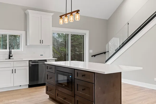 a large kitchen with stainless steel appliances kitchen island granite countertop a refrigerator a oven a island and a sink with cabinets