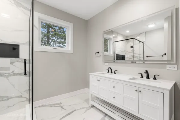a bathroom with a granite countertop shower a mirror and a toilet
