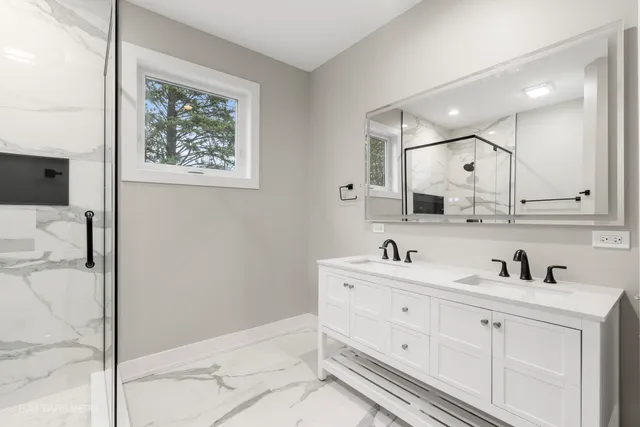 a bathroom with a granite countertop shower a mirror and a toilet