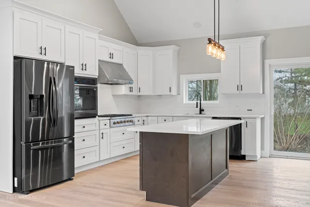 a kitchen with stainless steel appliances granite countertop a sink stove and refrigerator