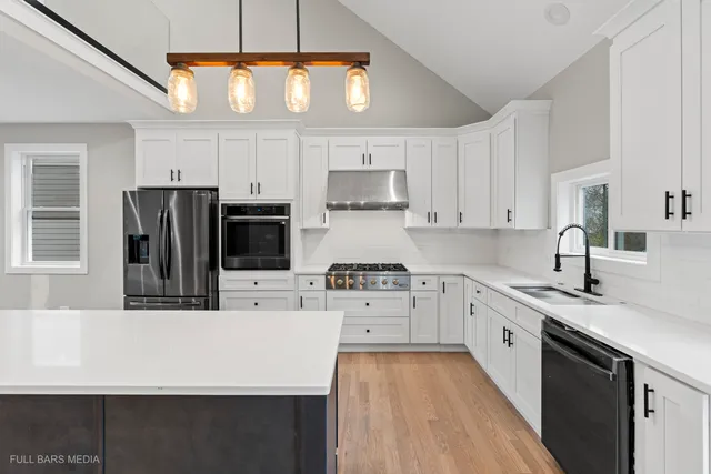 a kitchen with stainless steel appliances a sink stove and refrigerator