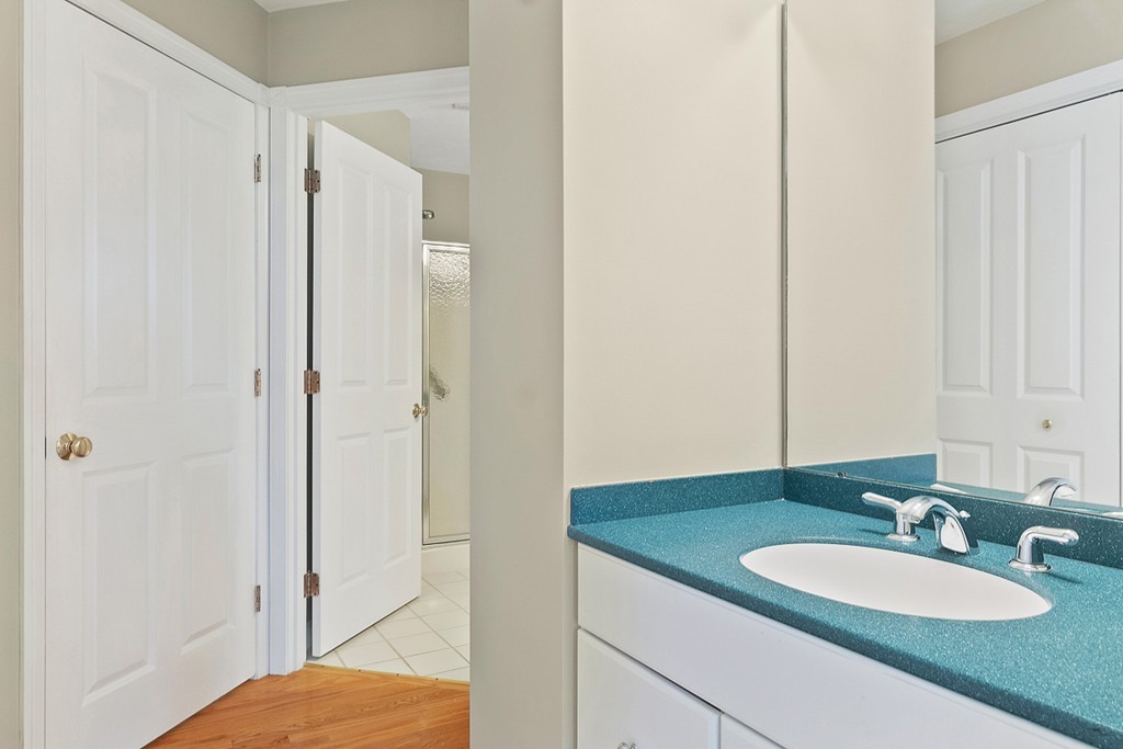 3 Strawberry Lane, Unit A Hudson, MA 01749 - Photo 18 of 29 a bathroom with a granite countertop sink and a mirror
