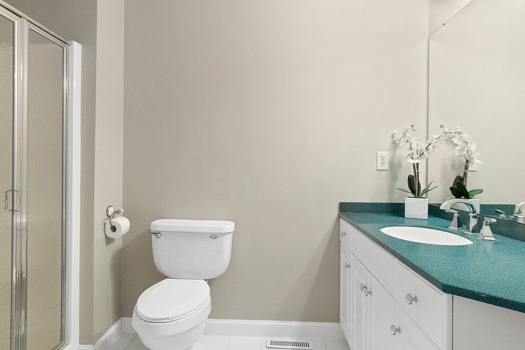 3 Strawberry Lane, Unit A Hudson, MA 01749 - Photo 20 of 29 a bathroom with a granite countertop sink a toilet and a mirror