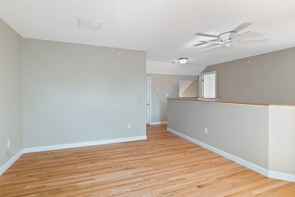 3 Strawberry Lane, Unit A Hudson, MA 01749 - Photo 21 of 29 a view of a big room with wooden floor and a ceiling fan