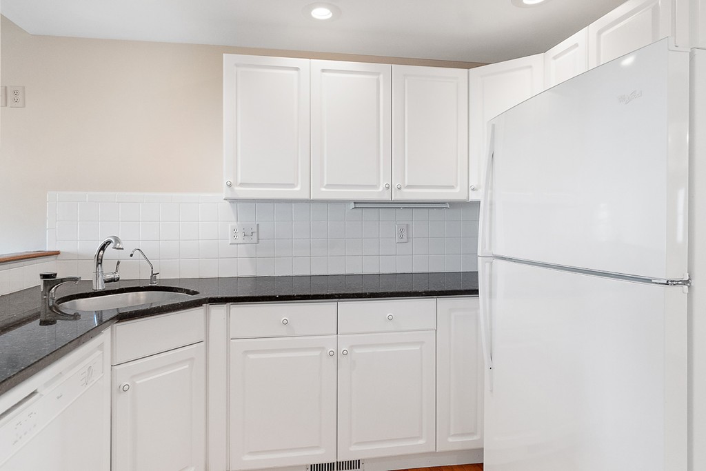 3 Strawberry Lane, Unit A Hudson, MA 01749 - Photo 8 of 29 a kitchen with granite countertop white cabinets and a refrigerator
