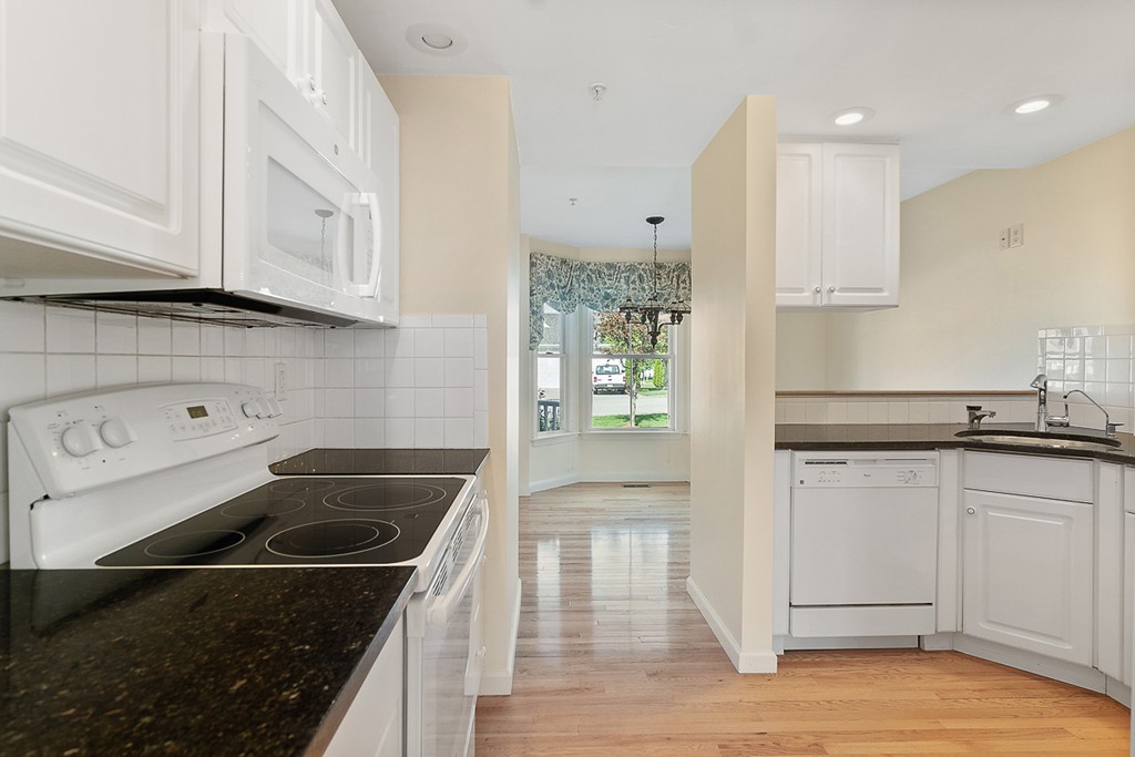 3 Strawberry Lane, Unit A Hudson, MA 01749 - Photo 9 of 29 a kitchen with a stove and white cabinets