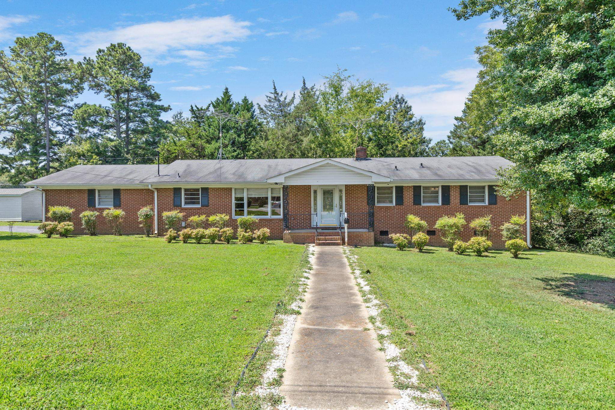 a front view of a house with a yard porch and wooden fence