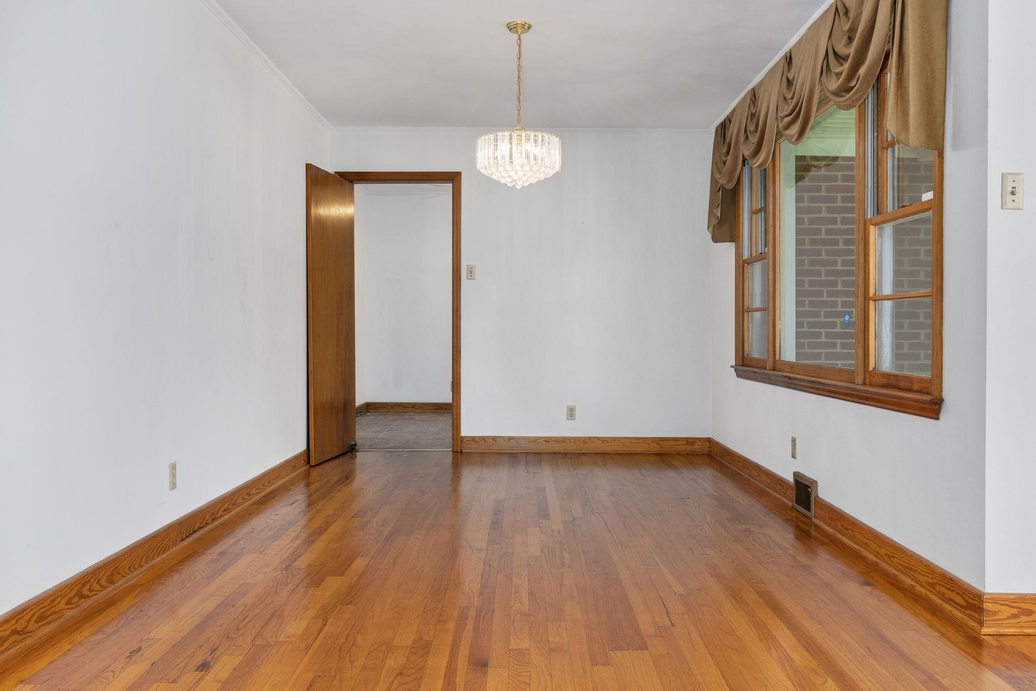 1309 Alpha Road Henderson, NC 27536 - Photo 11 of 26 a view of an empty room with wooden floor and a window