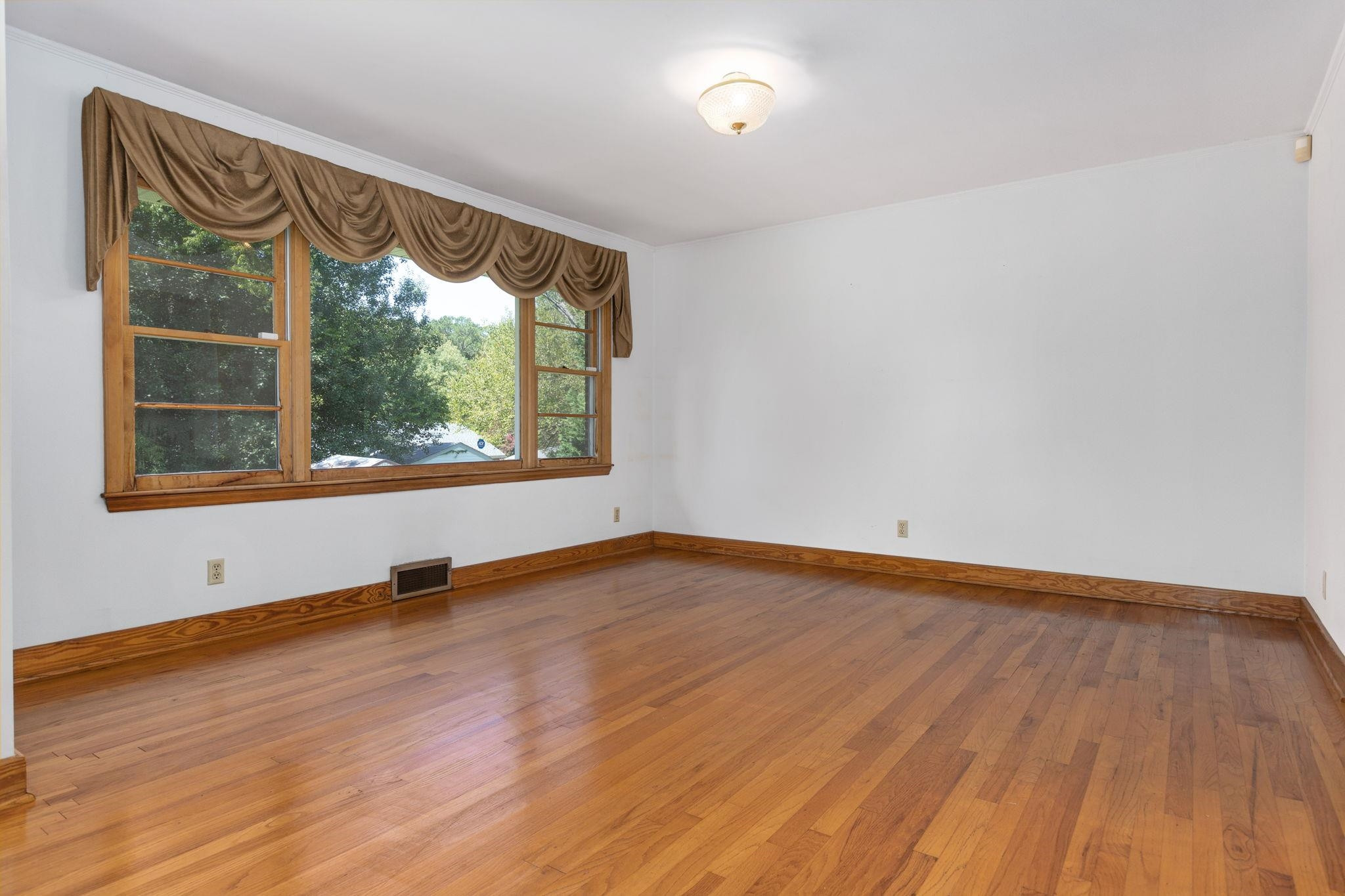 1309 Alpha Road Henderson, NC 27536 - Photo 12 of 26 a view of an empty room with wooden floor and a window