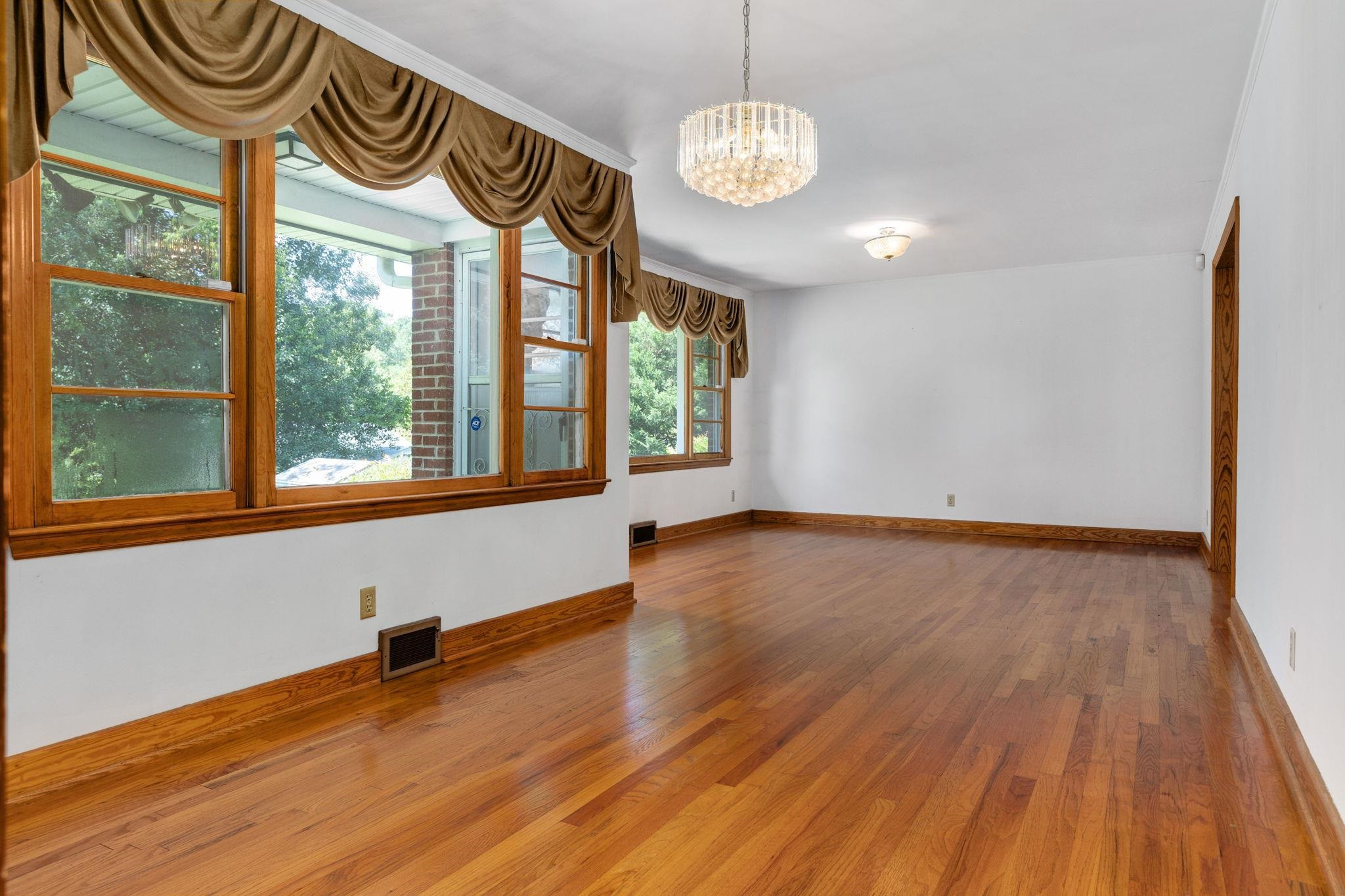 1309 Alpha Road Henderson, NC 27536 - Photo 13 of 26 a view of an empty room with a window and wooden floor