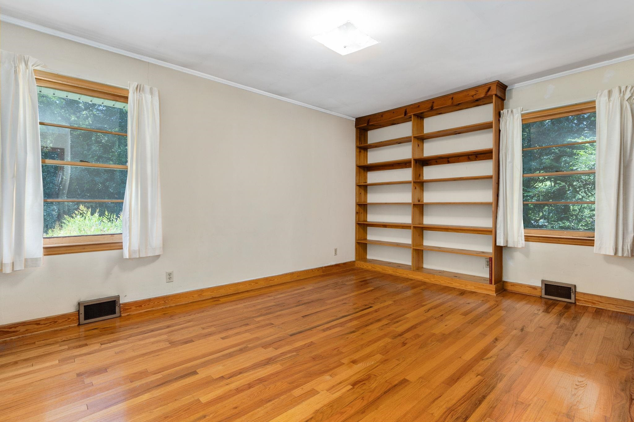 1309 Alpha Road Henderson, NC 27536 - Photo 22 of 26 a view of empty room with wooden floor and fan