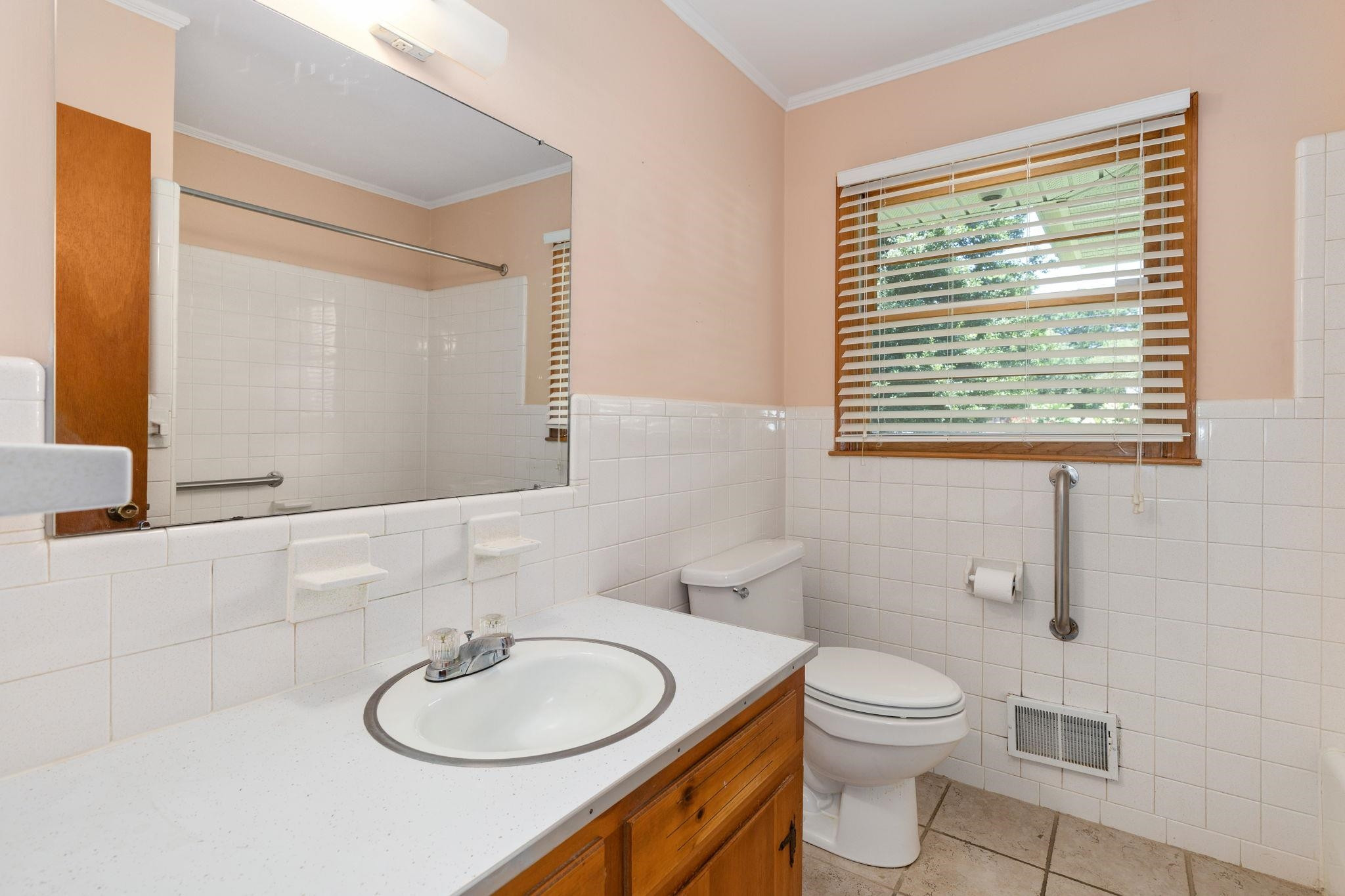 1309 Alpha Road Henderson, NC 27536 - Photo 23 of 26 a bathroom with a toilet a sink a mirror and a window