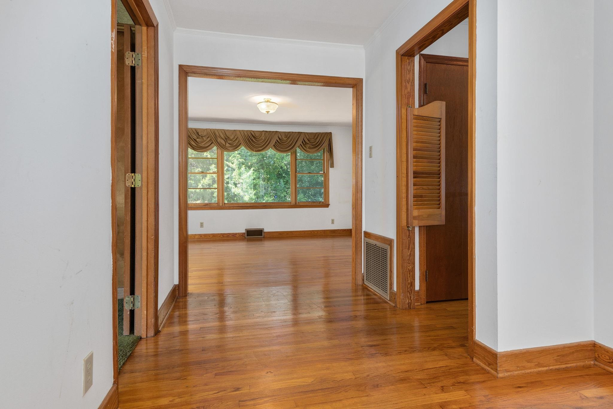 1309 Alpha Road Henderson, NC 27536 - Photo 8 of 26 a view of an empty room with wooden floor and a window