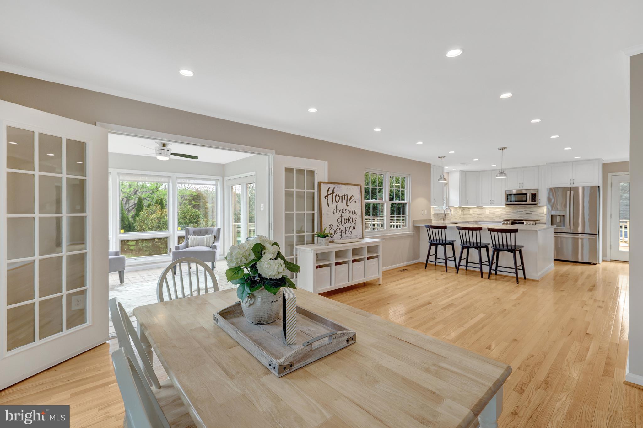1215 Bishopsgate Way Reston, VA 20194 - Photo 3 of 41 a living room with furniture a table and kitchen view with wooden floor