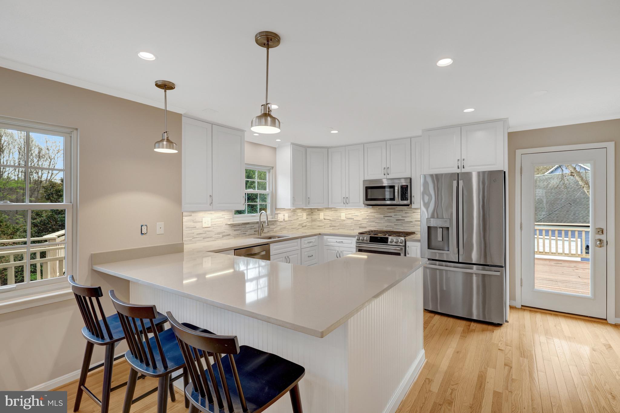 1215 Bishopsgate Way Reston, VA 20194 - Photo 6 of 41 a kitchen with refrigerator cabinets dining table and chairs