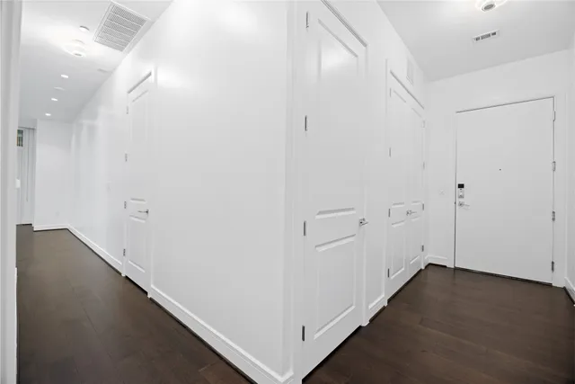 a living room with large couches next to a window with kitchen view
