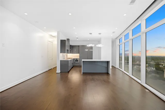 an empty room with wooden floor and window
