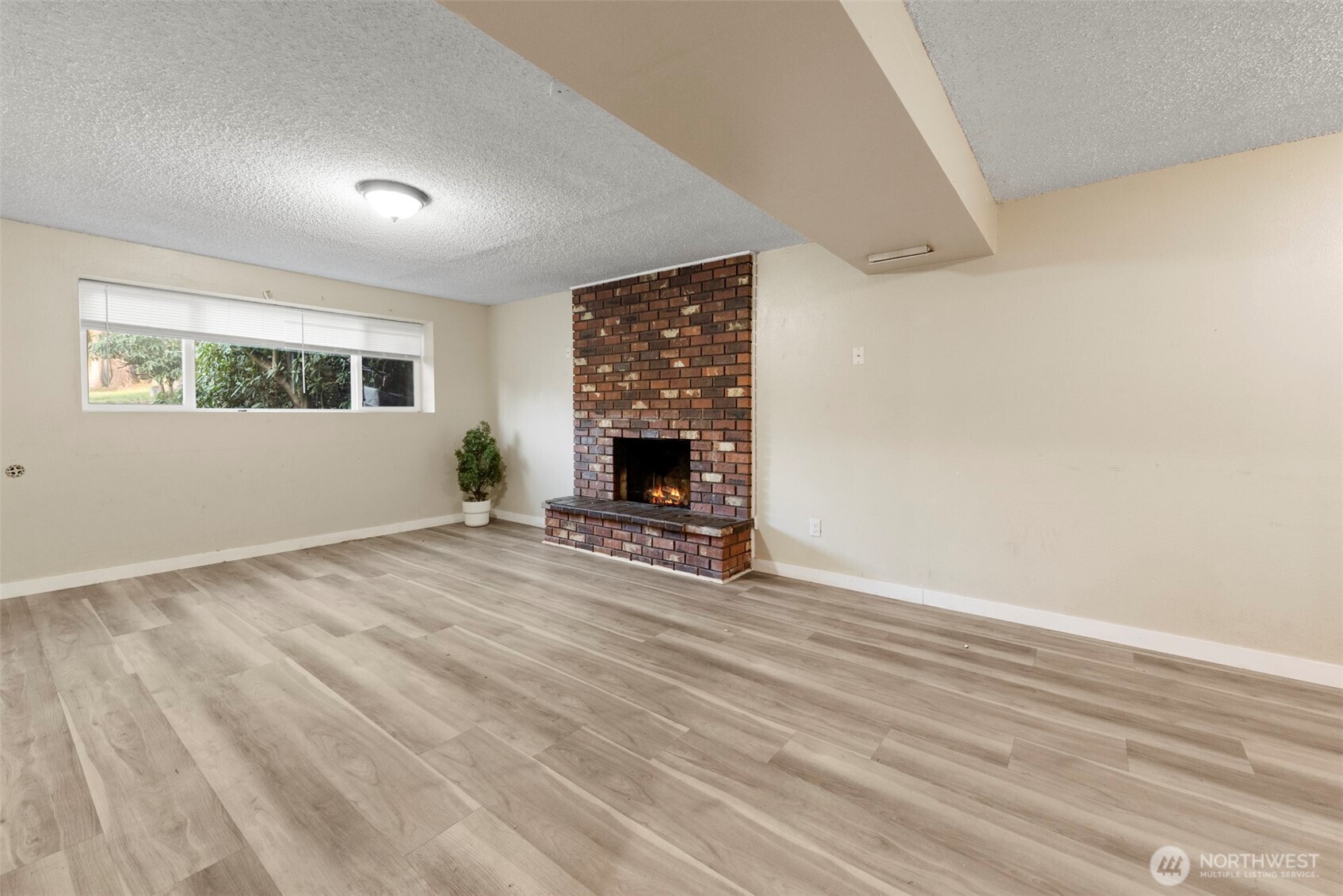 12727 Southeast 191st Place Renton, WA 98058 - Photo 17 of 23 a view of empty room with fireplace and wooden floor