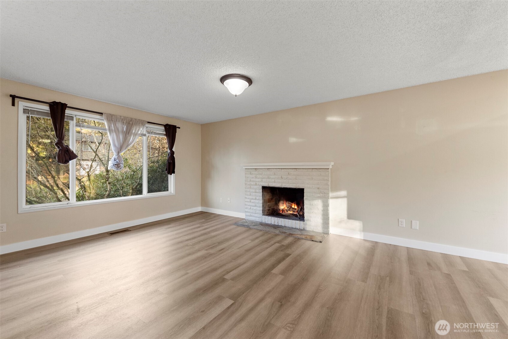 12727 Southeast 191st Place Renton, WA 98058 - Photo 3 of 23 a view of an empty room with a window and fireplace