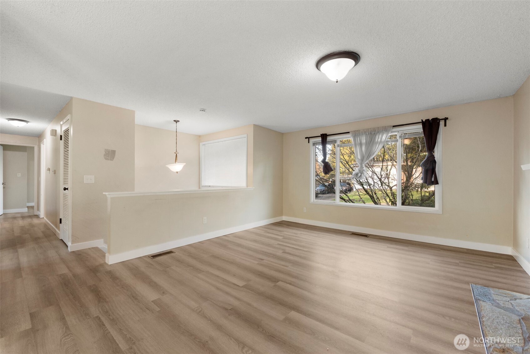 12727 Southeast 191st Place Renton, WA 98058 - Photo 4 of 23 a view of an empty room with wooden floor and a window